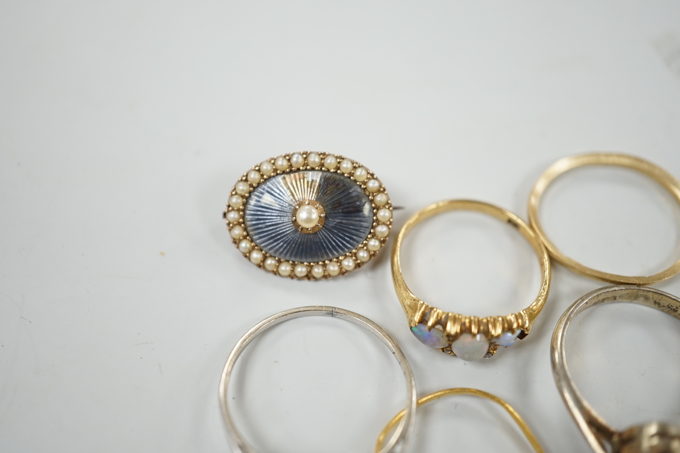 An early 20th century 18ct and three stone white opal set half hoop ring, with diamond chip spacers(one missing), size M, gross weight 2.5 grams, a 9ct band, 1 grams, a 22ct band(a.f.), 0.8 grams, two other rings includi
